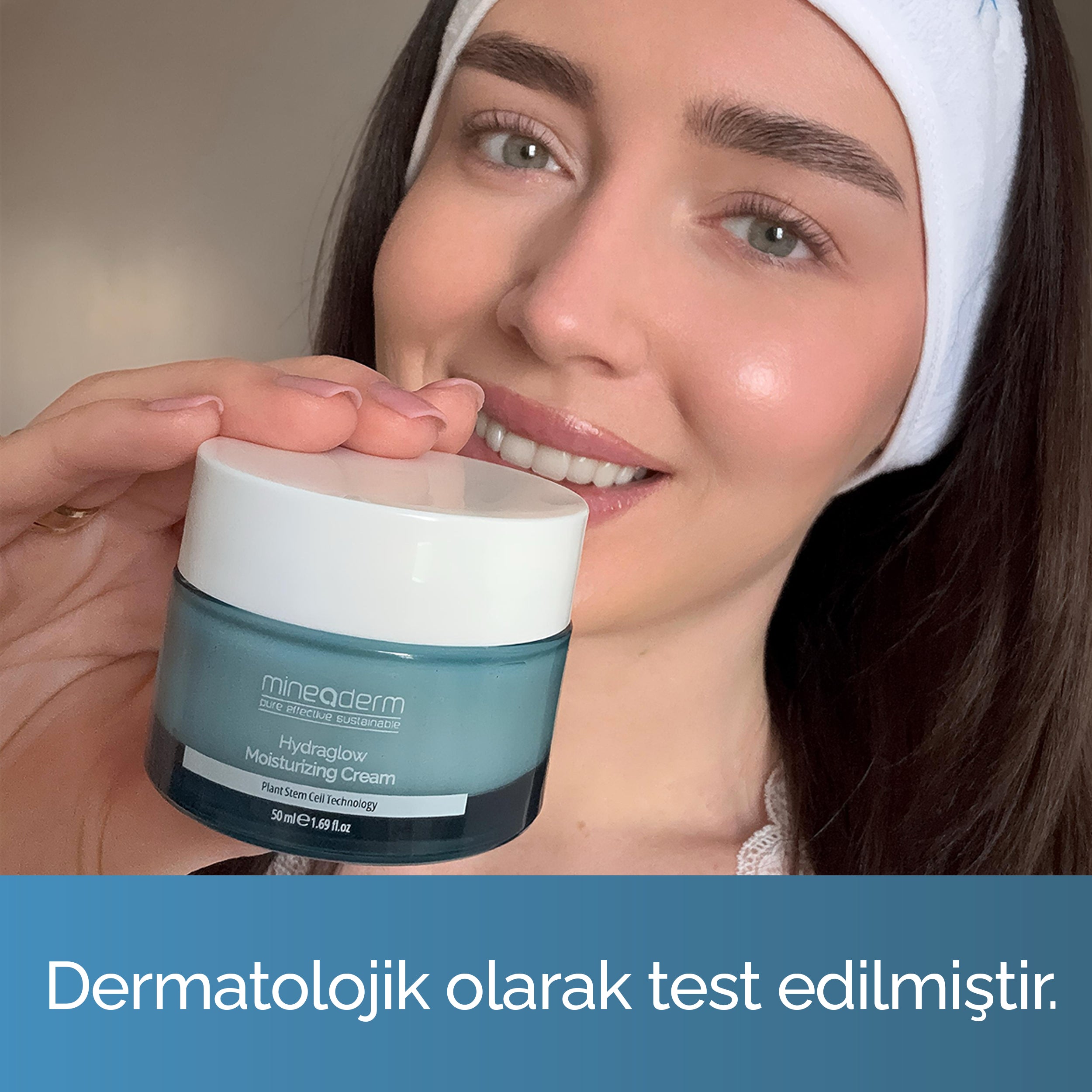 Gülümseyen bir kadın Mineaderm HydraGlow nemlendirici krem kavanozunu yüzünün yanında tutuyor; dermatolojik olarak test edilmiş günlük nemlendirici krem.