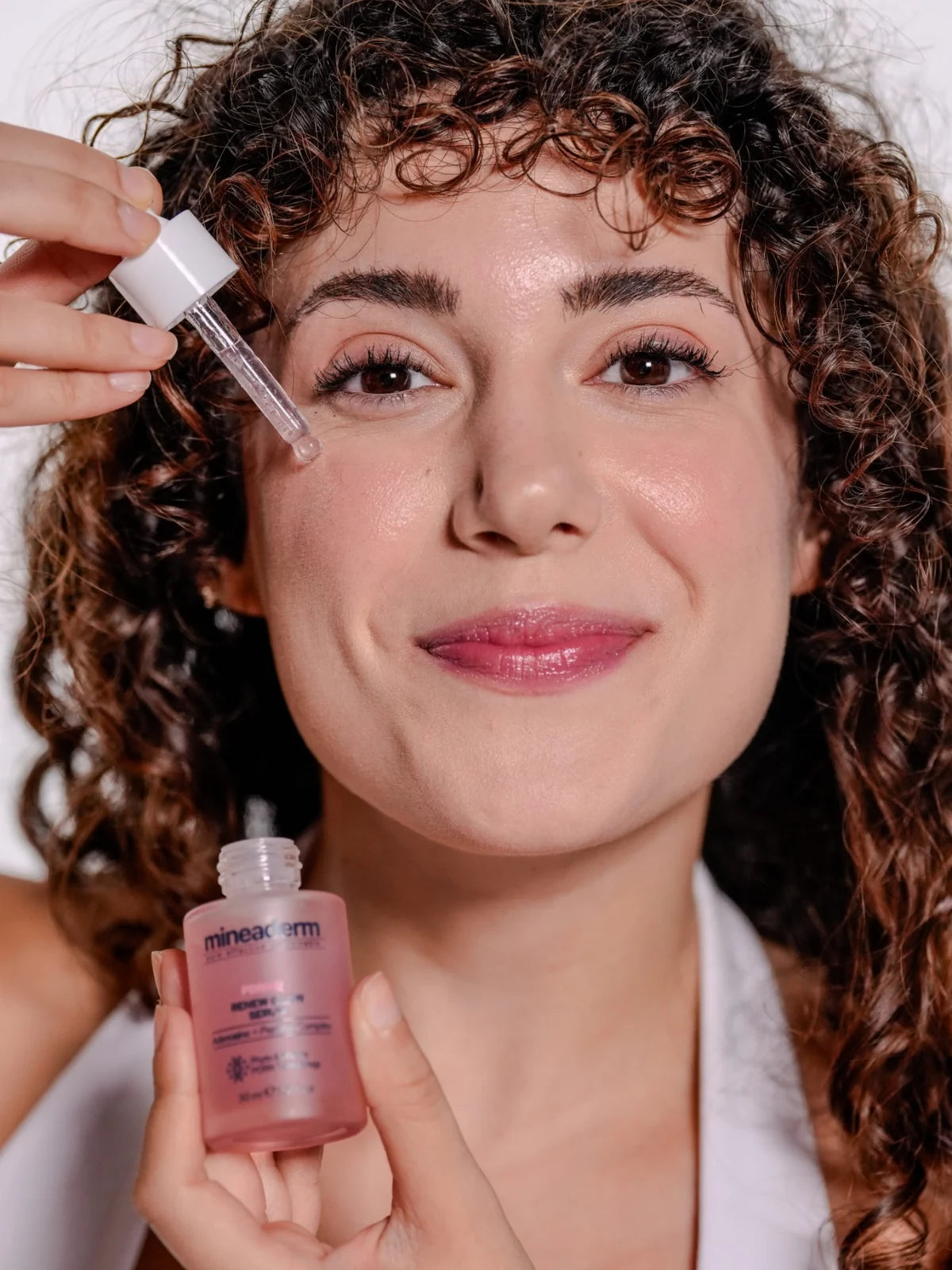 PDRN 6X Serum'u damlalıkla yüzüne uygulayan model